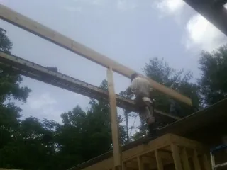 Carpenter setting a ridge beam over a new addition frame — Ice Dam Removal by Roofing Brothers in Lithia Springs