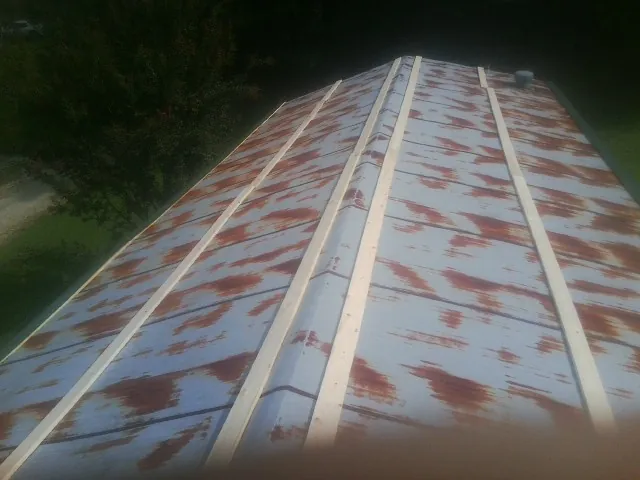 Rusted metal roof panels with new wood purlins before replacement — Storm Damage Roof Repair in Lithia Springs by Roofing Brothers