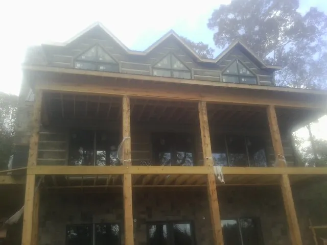 Dormers and porch framing on a large log home under construction — Roof Coating work by our crew in Lithia Springs