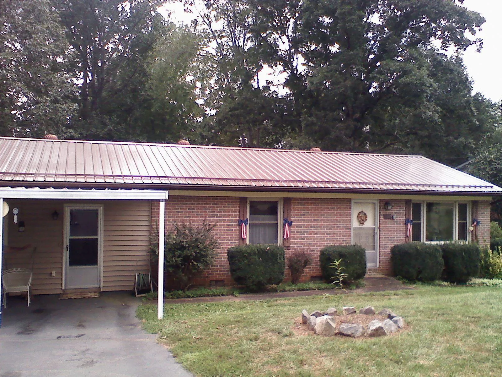 Bronze metal roof and carport on a brick ranch home — Roof Repair work by our crew in Lithia Springs