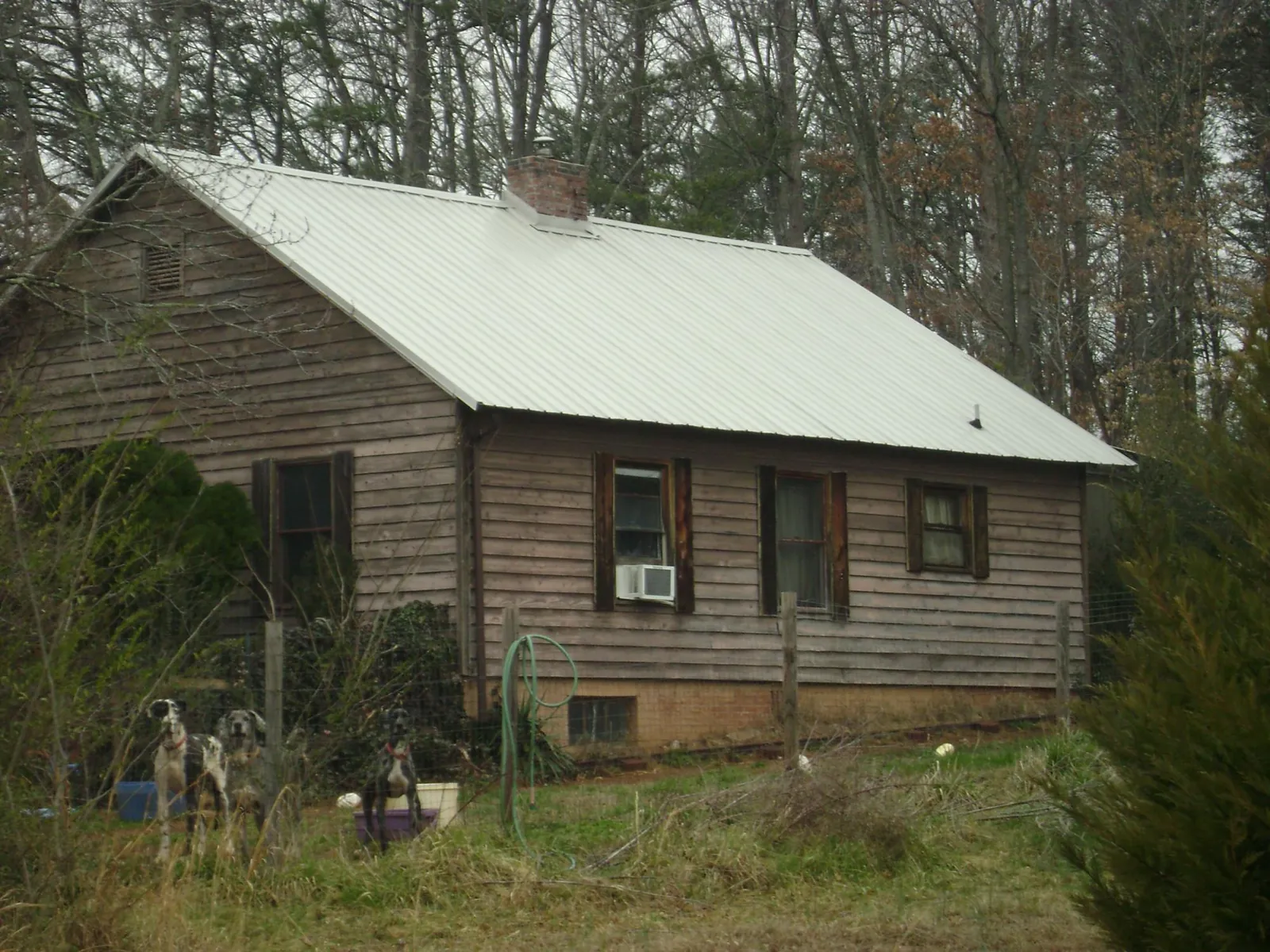 White metal roof on an old wood sided farmhouse, from a Metal Roof Installation job in Lithia Springs